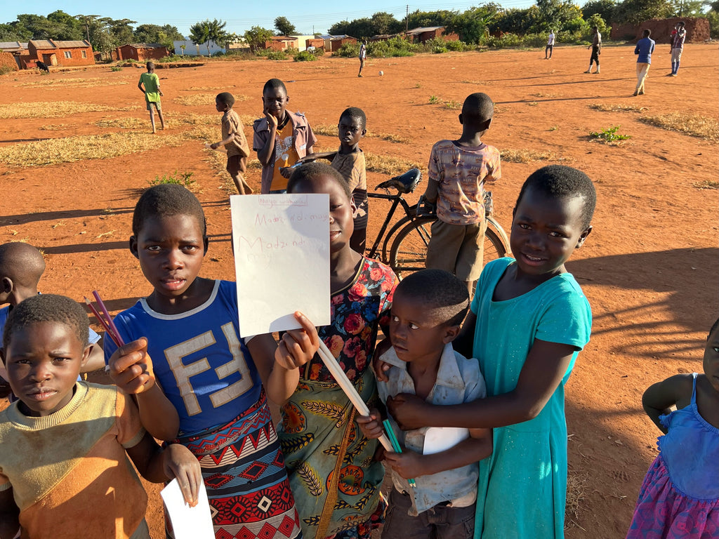 malawi children holding paper and pencils
